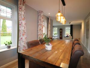 uma sala de jantar com uma mesa de madeira e cadeiras em Very spacious apartment in a converted farmhouse 