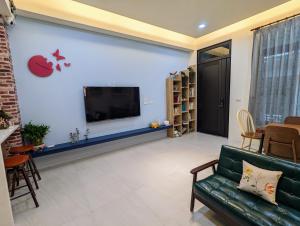 een woonkamer met een bank en een tv bij Ramble Travel Homestay in Guanshan