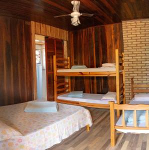 a room with three bunk beds and a ceiling at PETAR Pousada Núcleo Terra Iporanga in Iporanga