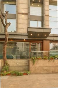 a building with a tree in front of it at Indus Biznotel in New Delhi