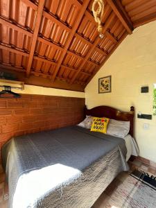 a bed in a room with a wooden ceiling at Hostel Sossego do Garças in Barra do Garças