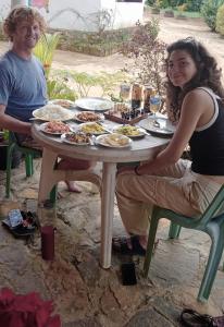 un hombre y una mujer sentados en una mesa con comida en Vegetable Garden House en Nallathanniya