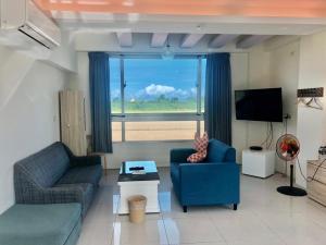 a living room with two couches and a large window at Running Kids B&B in Jiaoxi