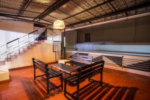 a room with a table and benches and a staircase at MK Residency in Coimbatore