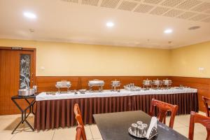 Cette chambre comprend une grande table avec des chaises et des tables. dans l'établissement MK Residency, à Coimbatore
