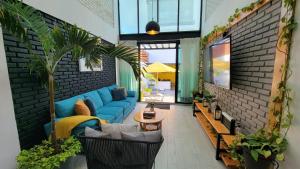 sala de estar con sofá azul y pared de ladrillo en CASA VILLA DEL SOL con alberca climatizada, en Tonatico