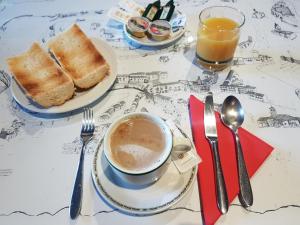 a table with a cup of coffee and two plates of toast at Hotel Puerta Sepúlveda in Sepúlveda