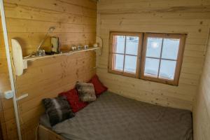 a small room with a bed in a log cabin at Drewniany domek pod masywem Śnieżnika in Nowa Morawa