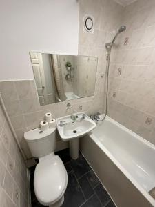 La salle de bains est pourvue de toilettes, d'un lavabo et d'une baignoire. dans l'établissement Spacious 2 bed Dulwich flat green views, à Londres