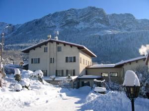 un edificio cubierto de nieve con montañas de fondo en Bon-Séjour, en Thollon-les-Mémises