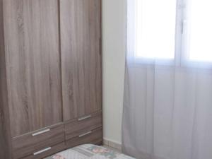 ein Schlafzimmer mit einem Holzschrank und einem Fenster in der Unterkunft Appartement Marseillan-Plage, 2 pièces, 4 personnes - FR-1-387-35 in Marseillan