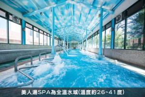 a swimming pool with blue water in a building at Formosan Naruwan Hotel in Taitung City