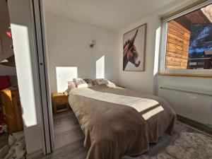 a bedroom with a bed and a window at La Foux d'Allos -Le Centre - Appartement T2 cosy et lumineux en cœur de station in La Foux