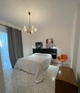 a bedroom with a bed and a desk and a chandelier at Casa Remolina in Montefollonico