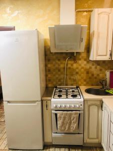 a kitchen with a stove and a white refrigerator at Julia in Umanʼ