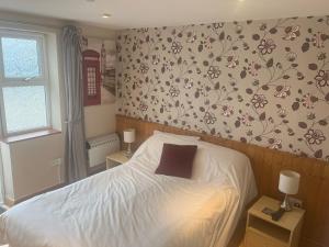 a bedroom with a bed with flowers on the wall at Chiverton arms in Chacewater