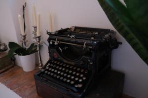 een ouderwetse typemachine met twee kaarsen en een plant bij Dimora Amina in Loreto Aprutino