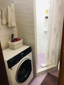 eine Waschmaschine im Bad mit Dusche in der Unterkunft Julia in Uman