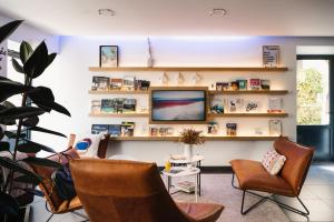 a living room with chairs and a tv and shelves at Urban Style LES FLEURINES in Villefranche-de-Rouergue