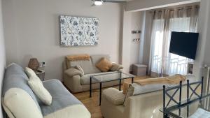 a living room with two couches and a flat screen tv at Apto en el Centro La Casita de Gaos Parking Gratuito in Granada