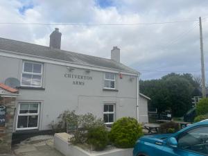 a white building with a sign on the side of it at Chiverton arms in Chacewater