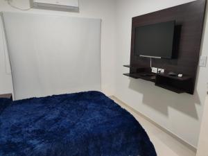 a bedroom with a bed and a flat screen tv at Punto de encuentro XL in Corrientes