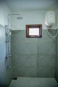 box doccia con finestra in bagno di Healand Holiday Bungalow and Restaurant a Deniyaya