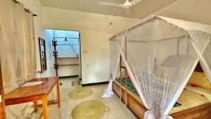 a bedroom with a bed with a mosquito net at Kihori Nungwi in Nungwi