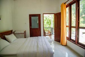 una camera con letto e balcone di Healand Holiday Bungalow and Restaurant a Deniyaya