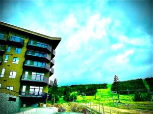 a building with a grassy hill in the background at Topp studio leilighet Alpine Lodge in Trysil