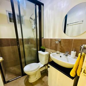 a bathroom with a toilet and a sink and a shower at Emotera Place @ Arezzo Place Davao in Davao City