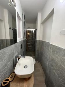 une salle de bain avec un lavabo blanc et une douche dans l'établissement Casa Genziana - nuovo bilocale in centro a Sestriere, à Sestrières