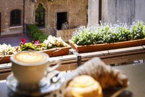 a cup of coffee sitting on a table next to flowers at Residenza...Cara Giulietta... in Verona