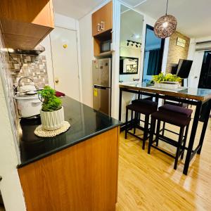a kitchen with a black counter top and a kitchen island at Emotera Place @ Arezzo Place Davao in Davao City +25 photos