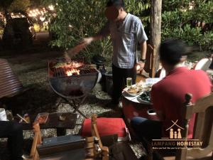 a man is cooking food on a grill at Lampang homestay2 in Lampang