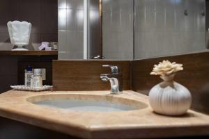 a bathroom sink with a vase with a flower in it at Residenza...Cara Giulietta... in Verona +23 photos