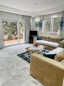 a living room with a couch and a tv at Villa avec j'ardin in Ariana