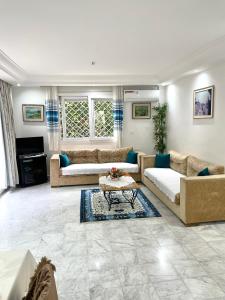 a large living room with couches and a coffee table at Villa avec j'ardin in Ariana