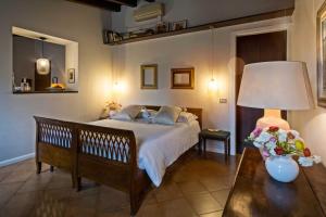 a bedroom with a bed and a table with a lamp at Residenza...Cara Giulietta... in Verona