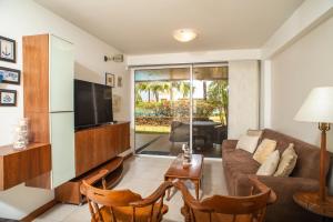 a living room with a couch and a tv at Bellos apartamentos en Loma Real, Pampatar in Pampatar