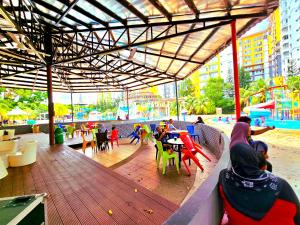 マラッカにあるMelaka BY LG Water Themepark & Resort Melaka By GGMの遊び場に座る人々