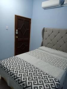 een slaapkamer met een bed en een bruine deur bij Casa de los abuelos in Salina Cruz