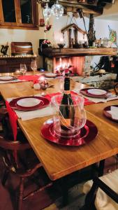 una mesa de madera con una botella de vino. en B&B Villa Claudia, en Lavena Ponte Tresa