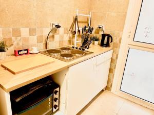 a kitchen with a sink and a stove top oven at Madinaty Comfort Residence in Madinaty +9 photos