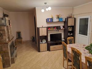 a living room with a table and a television at Casa Argentina in Cârțișoara