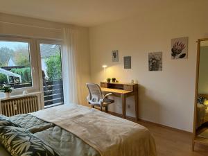 a bedroom with a bed and a desk and a window at Hennen-Nest in Sankt Ingbert