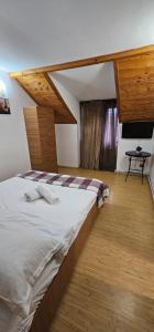 a bedroom with a large bed and a flat screen tv at Casa Sabina in Pucioasa