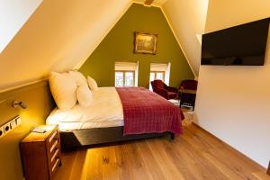 a bedroom with a bed and a tv in a attic at Wirtshaus zum Drachen Marokko Schenke in Margetshöchheim