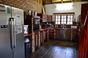 een keuken met een koelkast en een bakstenen muur bij Bona Ngwenya Lodge & Safaris in Marloth Park