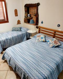 1 dormitorio con 2 camas y edredones azules en Villetta Blu, en Rio nellʼElba